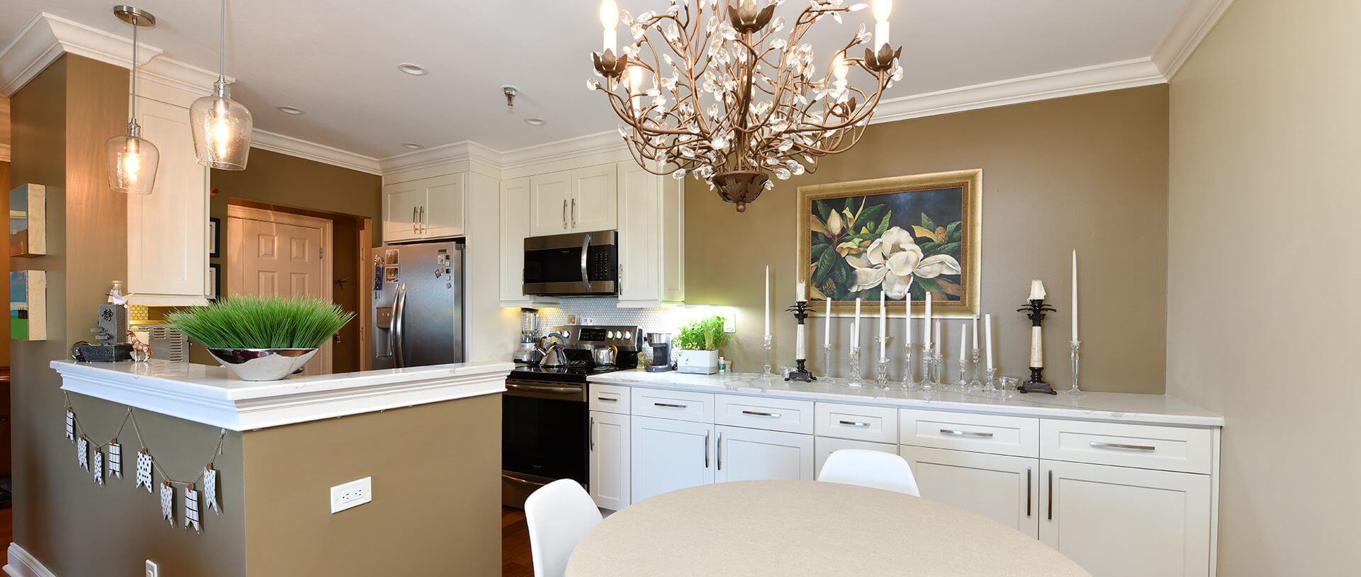 Modern white kitchen with chandelier and island