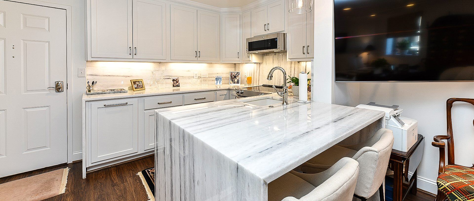 Modern white kitchen with marble waterfall island