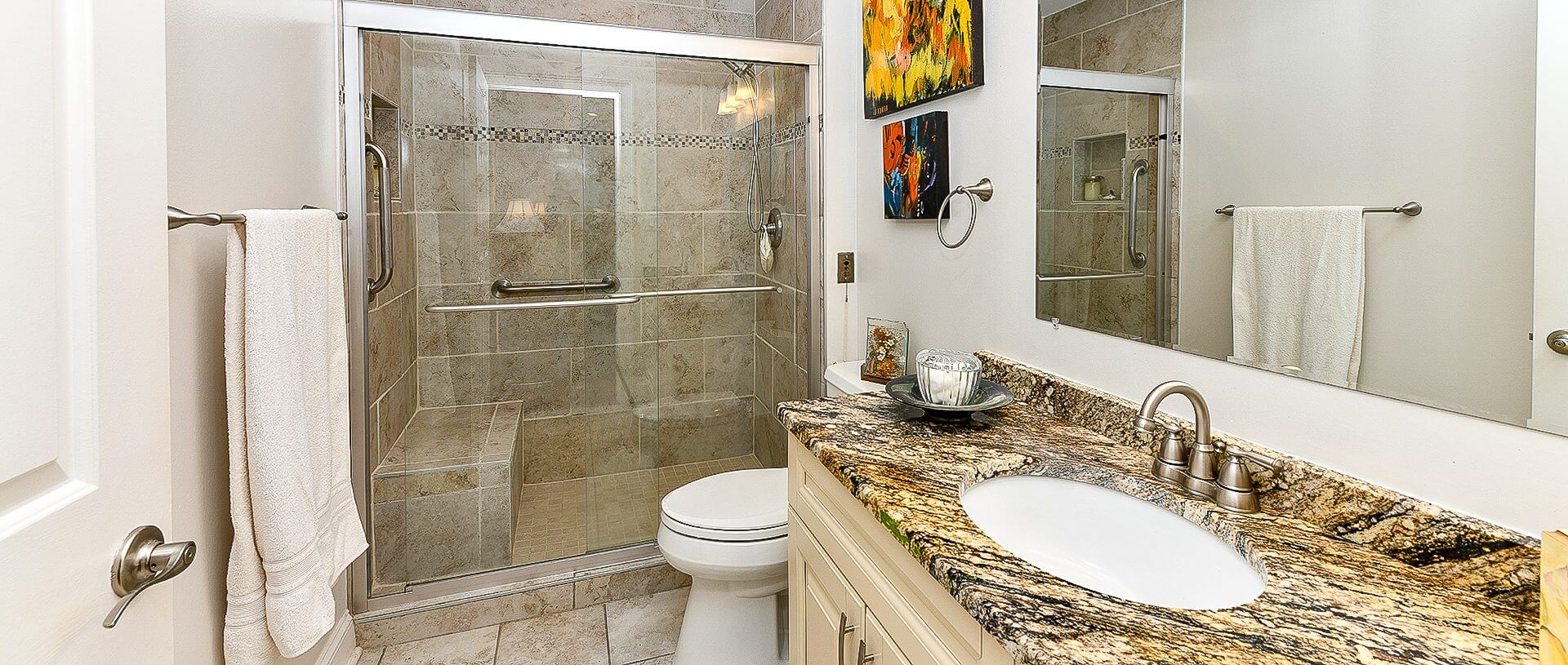 A bathroom with marble counter tops and tile floors.