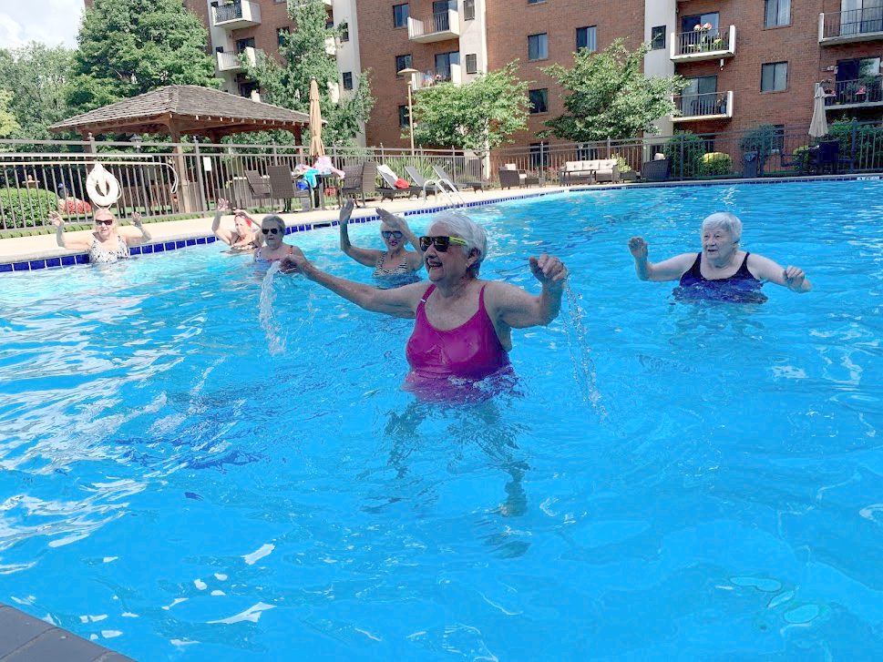 A group of people in the pool playing with water.